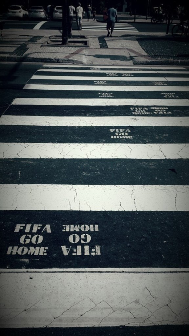 Eine Zebrastreifenübergang mit ein paar Menschen, die darüber gehen, und ein paar Autos in der linken oberen Ecke.