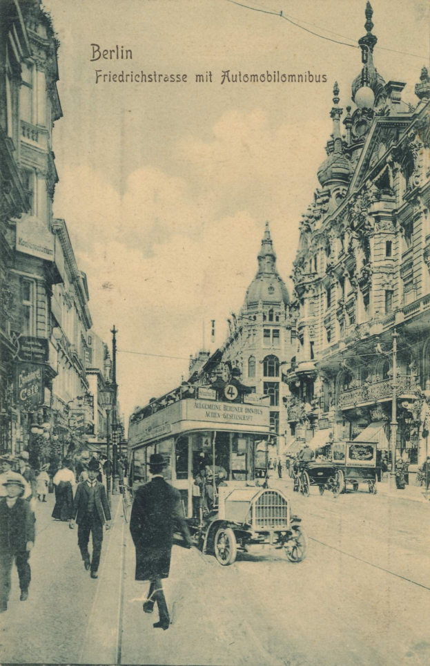 Ein altes Schwarz-Weiß-Foto von Menschen, die eine Straße in Berlin, Deutschland, entlanggehen, mit Fahrzeugen, Gebäuden und einem bewölkten Himmel, und Text oben.