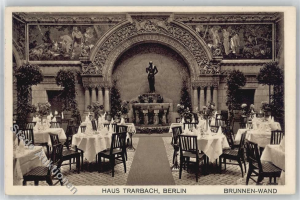 Ein altes Schwarz-Weiß-Foto eines Berliner Restaurants mit Tischen, Stühlen, Blumenvasen, einer Statue, Skulpturen und Pflanzen an den Wänden, mit Text unten.