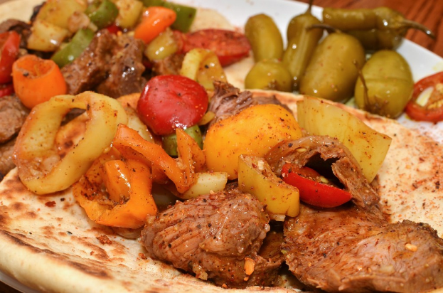 Ein Teller mit Tomaten, Chilischoten und Hähnchen.