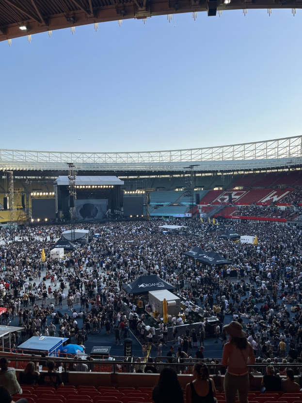Große Menschenmenge auf einem Stadion mit Zelten, Geländern und Beleuchtung an der Decke während eines Events in der O2 Arena in London.