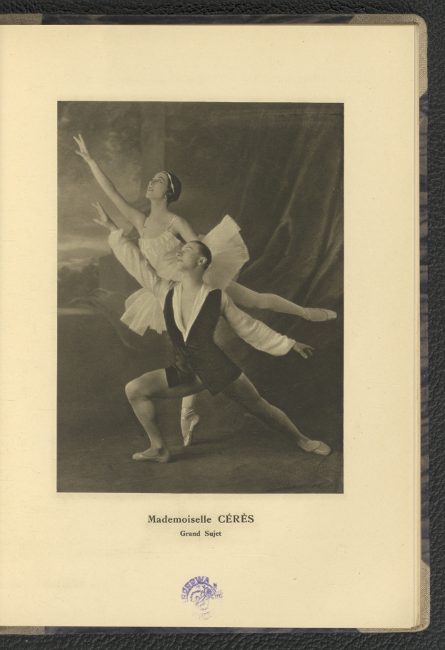 Ein Schwarz-Weiß-Foto eines Mannes und einer Frau in Ballettkleidung, die perfekt synchron tanzen, wobei der Mann ein weißes Tutu trägt und die Frau ein rosafarbenes Kleid, Text unten im Rahmen.