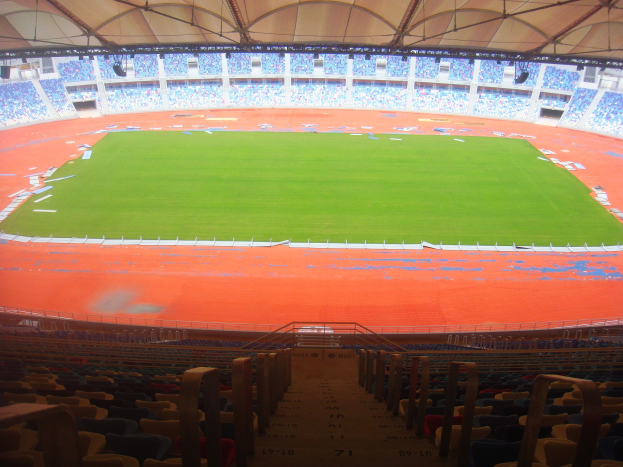 Großes Stadion mit vielen Sitzplätzen, Balkonen, Treppen, Dach und einem sichtbaren Spielfeld in der Mitte.