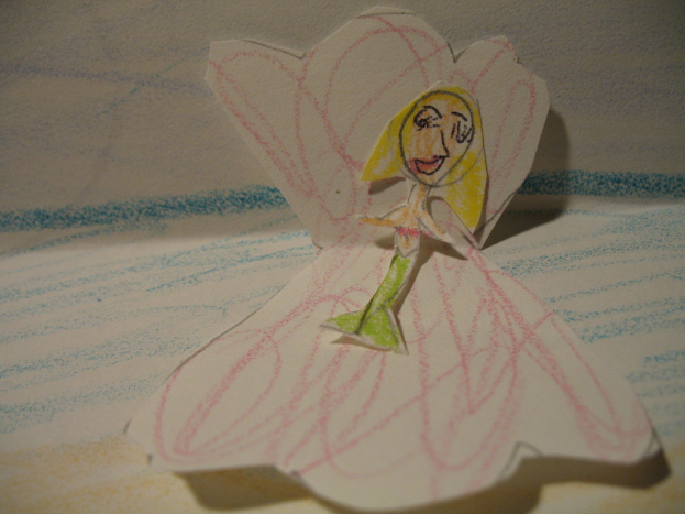 Papierkunstwerke und Skizzen auf einer Oberfläche.