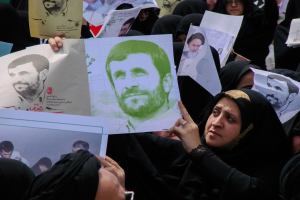 Eine Gruppe iranischer Frauen in schwarzer Kleidung, einige mit Brille, halten Fotos von Präsident Mahmoud Ahmadinejad während einer Demonstration in Tehran hoch.