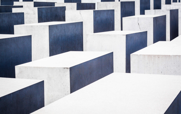 Ein Feld rechteckiger Betonplatten in verschiedenen Höhen, die in einem Gittermuster angeordnet sind, bekannt als Holocaust-Mahnmal für die ermordeten Juden Europas, befindet sich in Berlin, Deutschland.