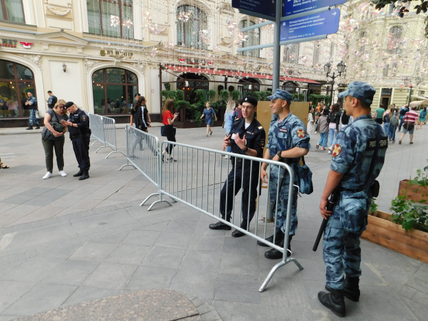 Polizeibeamte in Uniform stehen hinter Absperrungen und blicken auf eine Menge, einige halten Waffen, während eines Anti-Terror-Einsatzes in Wien, Österreich.