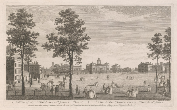 Eine Gruppe von Menschen, die während eines Umzugs im St. James Park steht und sitzt, mit Bäumen und Gebäuden im Hintergrund unter einem bewölkten Himmel.
