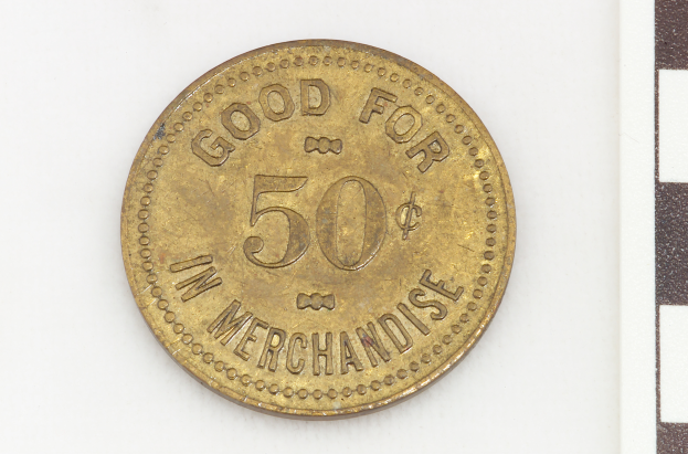 Eine Goldmünze mit der Aufschrift "Gut für 50 im Handel" vor einem weißen Hintergrund.