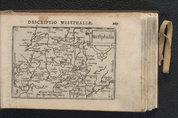 Ein aufgeschlagenes Buch, das eine detaillierte Karte der westfälischen Geographie auf einem schwarzen Untergrund zeigt.