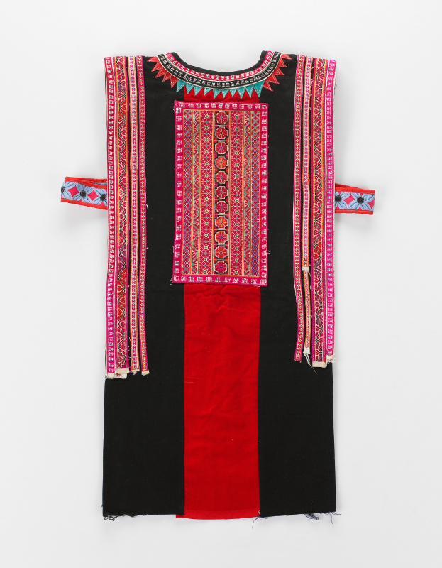 Ein schwarzes und rotes Kleid mit farbenfroher, mehrfarbiger Stickerei, vor einem weißen Hintergrund.