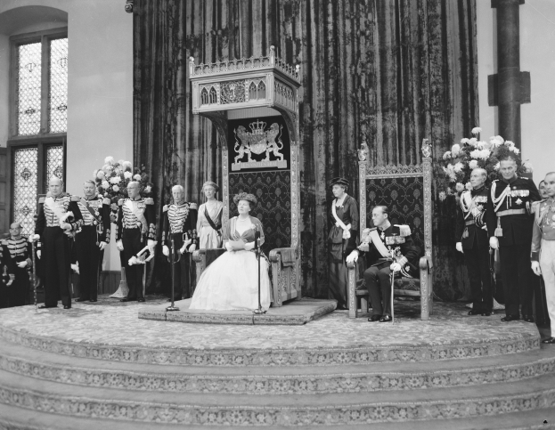 Königin Elizabeth II. und Prinz Philip, Duke of Edinburgh, auf ihrer Hochzeit sitzend mit Begleitern, die Blumensträuße halten.