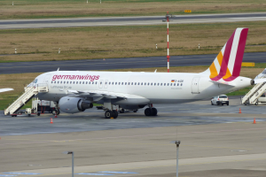 Germanwings Airbus A320-200 am Frankfurt Airport mit Bodenfahrzeugen, Verkehrskegeln, Pfählen und Gras im Hintergrund.